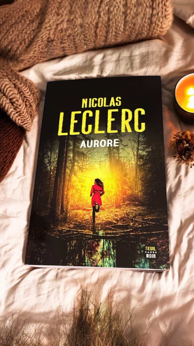 Livre Aurore de Nicolas Leclerc posé sur un plaid ivoire avec une tasse de thé, roman sombre et addictif